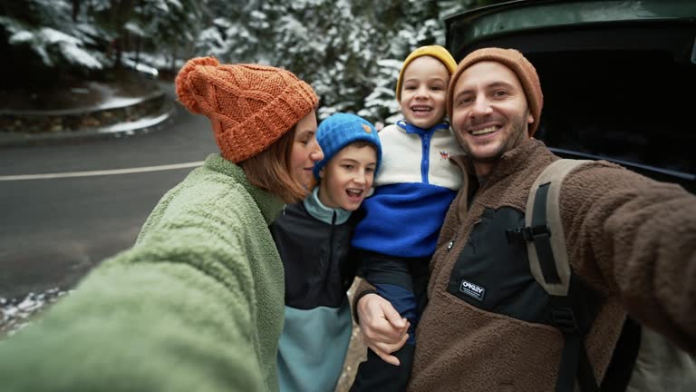 Família junto ao automóvel durante uma viagem na montanha