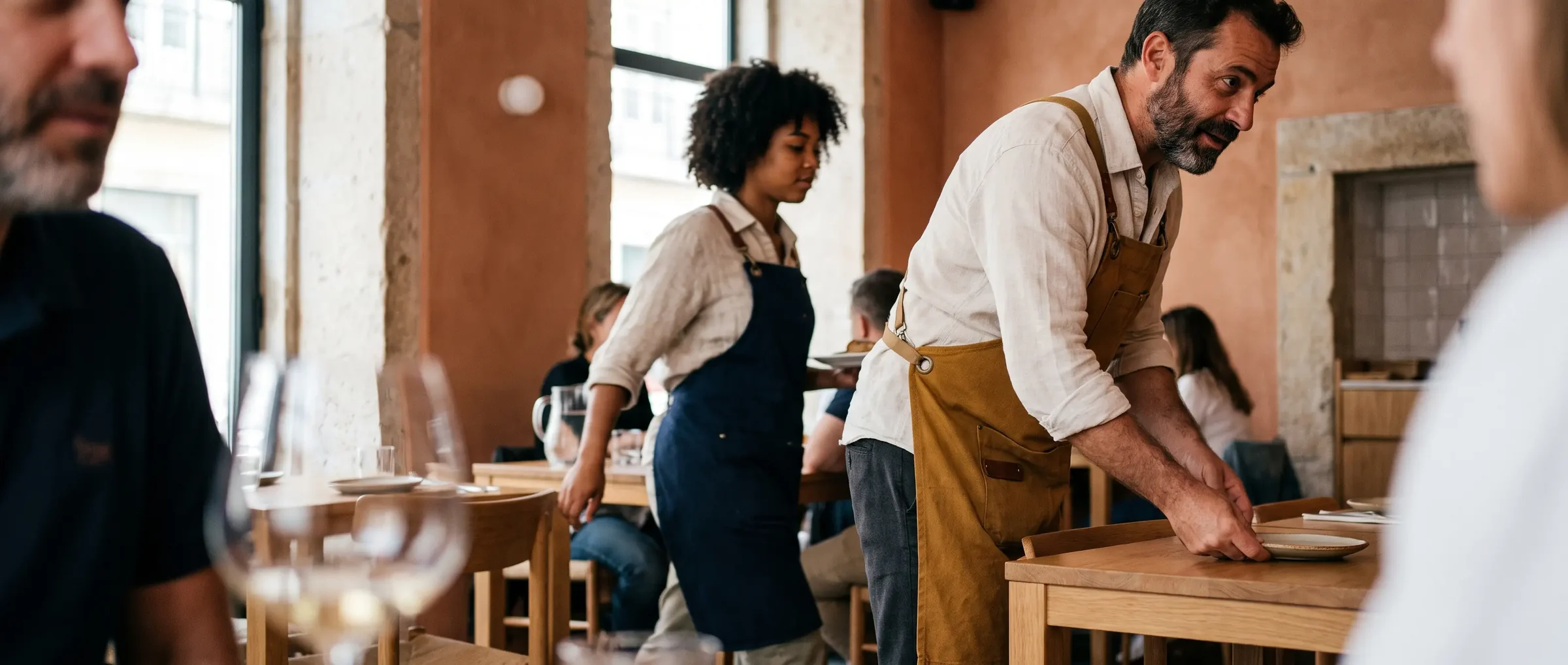 Profesional de hostelería preparando una mesa con delantal